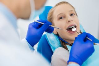 dentista cura denti a bambino
